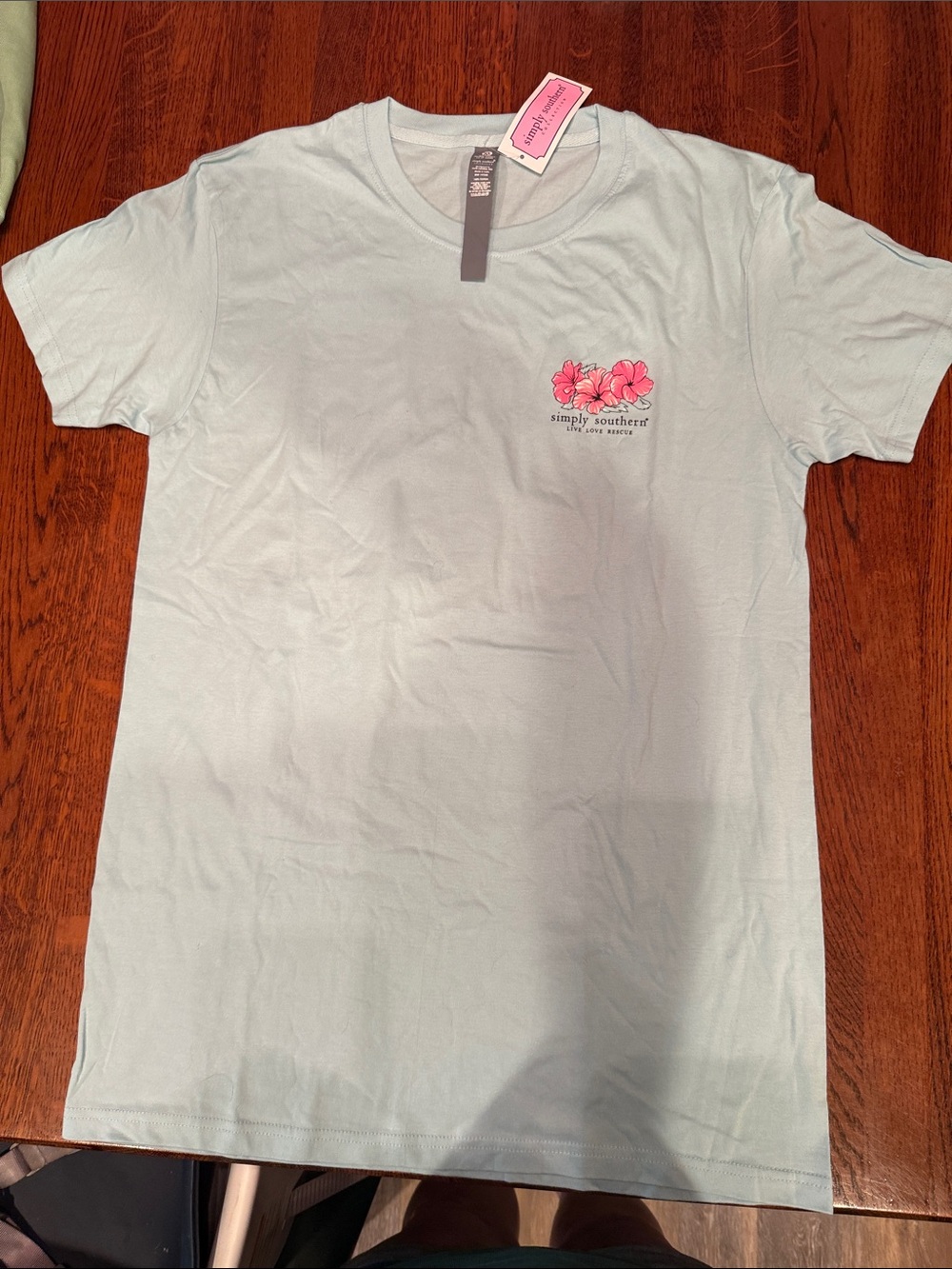 Simply Southern Woman’s Pale Blue Tee with Pink Floral Chest Logo